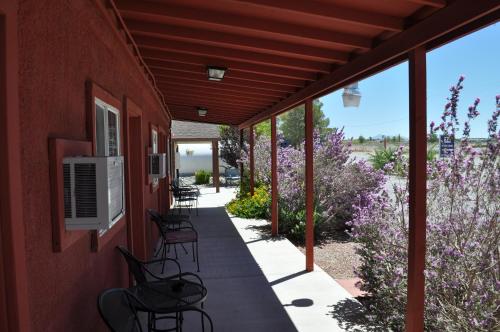 a covered porch with chairs and purple flowers at K7 Bed and Breakfast in Pahrump