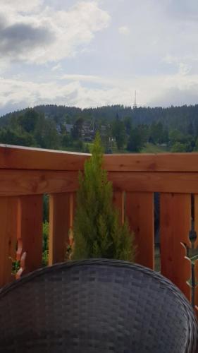 a table on a wooden deck with a tree at Villa Fortuna - Regionalne apartamenty & SPA - Sauna, Grill, Jacuzzi z widokiem na Tatry in Zakopane