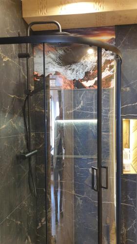 a glass door to a shower in a room at Villa Fortuna - Regionalne apartamenty & SPA - Sauna, Grill, Jacuzzi z widokiem na Tatry in Zakopane