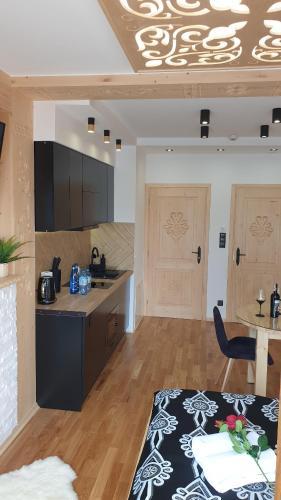 a kitchen and dining room with a table and a counter at Villa Fortuna - Regionalne apartamenty & SPA - Sauna, Grill, Jacuzzi z widokiem na Tatry in Zakopane