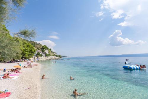 a group of people on a beach in the water at Apartments Klaric in Krilo