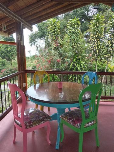 einen Tisch und Stühle auf einem Balkon mit Tisch und Stühlen in der Unterkunft Finca San Miguel Filandia in Filandia