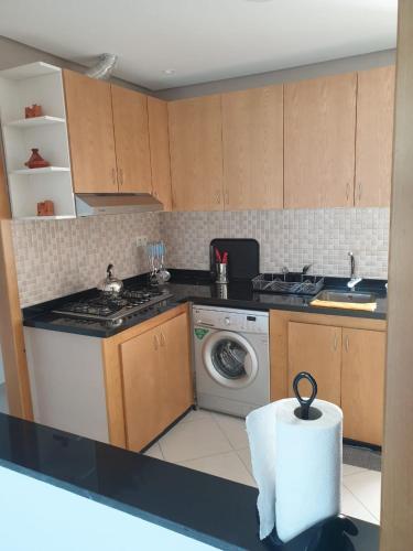 a kitchen with a washing machine and a dishwasher at Appartement Al Amal in Martil