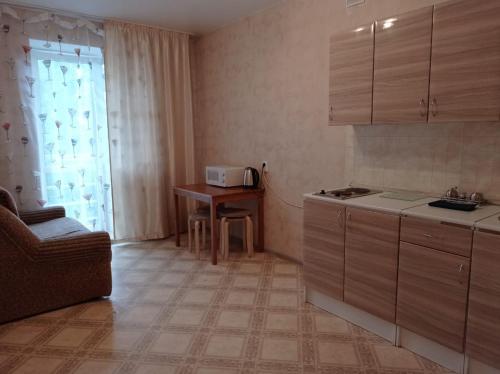 uma pequena cozinha com uma mesa e uma cadeira em 1к. Апартаменты НСК , на пр.Карла Маркса 11 em Novosibirsk