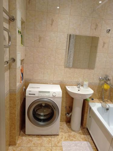 uma casa de banho com uma máquina de lavar roupa e um lavatório em 1к. Апартаменты НСК , на пр.Карла Маркса 11 em Novosibirsk