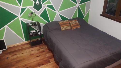 a bedroom with a bed with a green and white wall at Casa de verano con Pileta, Quincho y Garage Parque Luro MDP in Mar del Plata