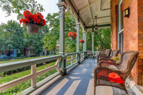 a porch with wicker chairs and red flowers on it at Hochelaga Inn in Kingston