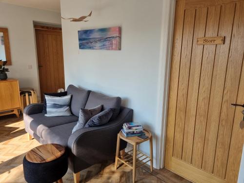 a living room with a couch and a table at Glenfalloch Beag Apartment, Torvaig in Portree