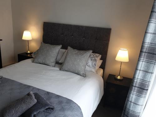 - une chambre avec un grand lit blanc et deux lampes dans l'établissement Kingfisher cottage, à Worthing