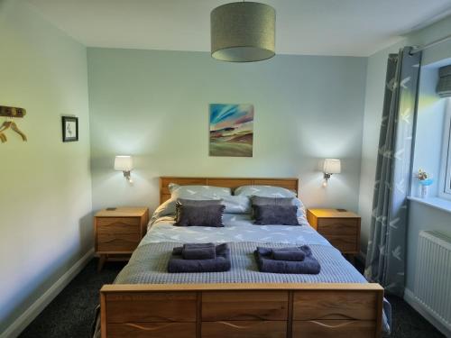 a bedroom with a large bed with blue pillows at Glenfalloch Beag Apartment, Torvaig in Portree