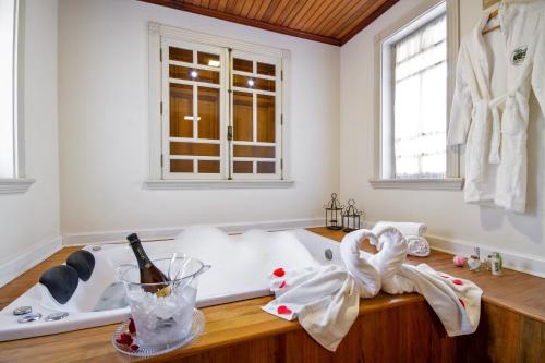 ein Badezimmer mit einer weißen Badewanne und einem Fenster in der Unterkunft Pousada Do Conde in Campos do Jordão