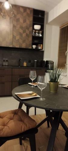 a table with two wine glasses on it in a kitchen at Apartamenty Osmolice w Stawach in Dęblin