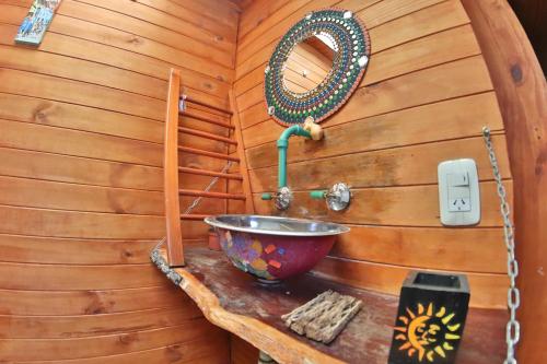 Cabaña de madera con lavabo y espejo en Casita del arbol Hostel en San Salvador de Jujuy