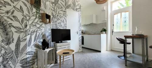 un salon avec une télévision sur un mur dans l'établissement Dormiraneris Résidence Amaryllis, à Néris-les-Bains