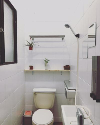 a white bathroom with a toilet and a sink at PageSurfingInn in Donghe