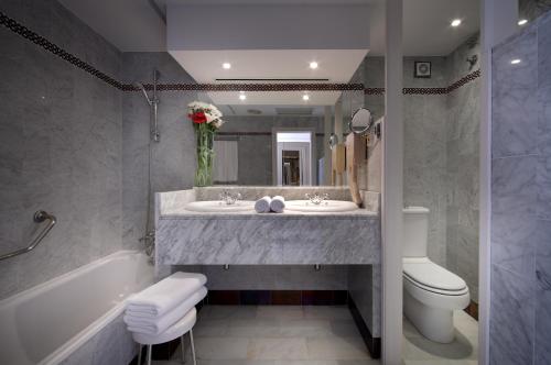 bagno con lavandino, vasca e servizi igienici di Hotel Abades Benacazon a Benacazón