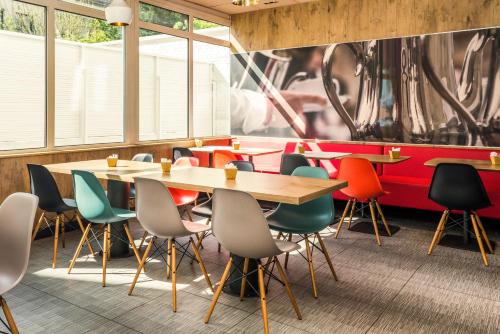 a restaurant with tables and chairs and a mural at ibis Paris Boulogne Billancourt in Boulogne-Billancourt