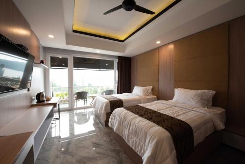 Habitación de hotel con 2 camas y TV de pantalla plana. en Dedanau Hotel en Bedugul