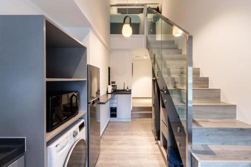 a hallway with a staircase and a living room at Heritage Collection on Boat Quay - Quayside Wing - A Digital Hotel in Singapore