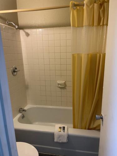 uma casa de banho com uma banheira e uma cortina de chuveiro amarela em Bravo Inn em Johnson City