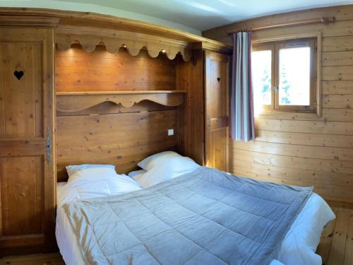 a bedroom with a large bed with a wooden wall at Appartement Les Saisies, 3 pièces, 6 personnes - FR-1-293-356 in Hauteluce