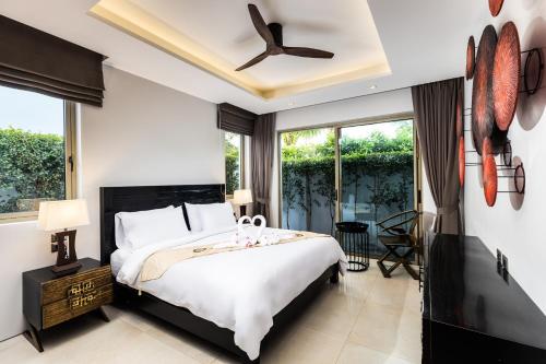 a bedroom with a bed and a ceiling fan at Harmony villa Botanica Bangtao in Bang Tao Beach