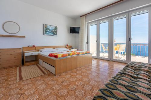 a bedroom with a bed and a balcony with the ocean at Apartments Laura in Dramalj