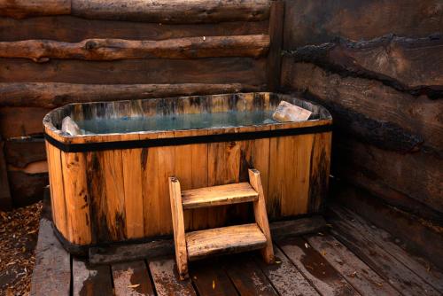 a wooden bath tub with a wooden chair next to it at El Encanto del Manzano & Espacio Vittalia Spa in San José de Maipo