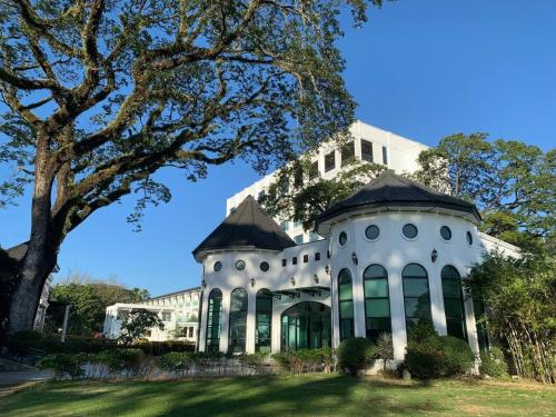 a large white mansion with a tree at Hotel Seoul in Clark