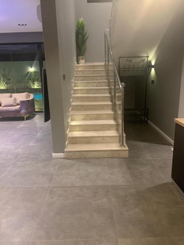 a staircase in a living room with tile floors at View Villas in Buraydah