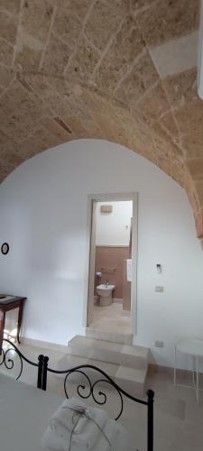 a room with a hallway with a sink and a mirror at Asylum Amicorum Bed & Breakfast in Gagliano del Capo