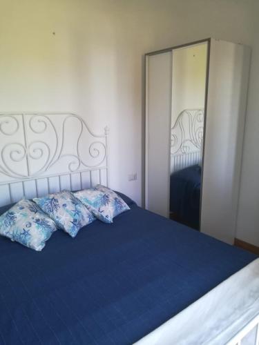 a bedroom with a blue bed with a large mirror at Appartamentino in villa a 2 passi dal mare in Fontane Bianche