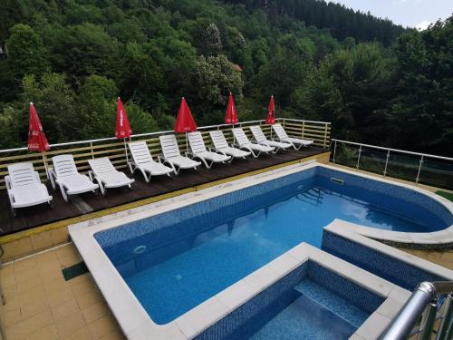 uma piscina no topo de um edifício com cadeiras em Guest House Shipkovo Hills em Shipkovo