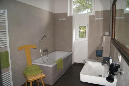 a bathroom with a bath tub and a sink at Altstadthaus Cityappartements in Graz