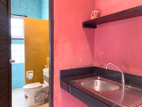 baño con lavabo y pared roja en Flora Ville-SHA PLUS en Chalong 