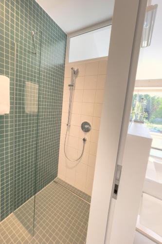 a bathroom with a shower with green tiles at HAAUS in Weinstadt