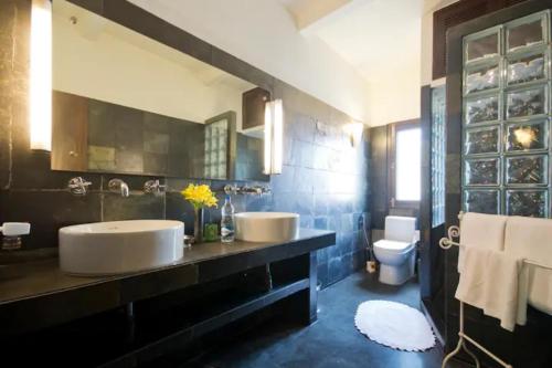 ein Badezimmer mit zwei Waschbecken und einem WC in der Unterkunft Zaza Stay in Neu-Delhi