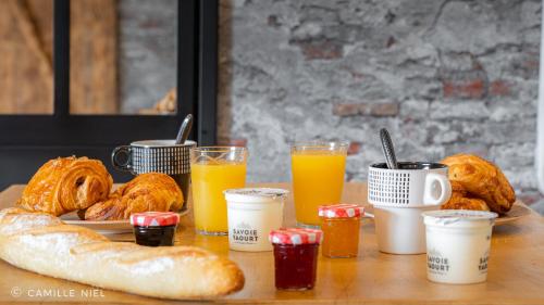 - une table recouverte d'une assiette de viennoiseries et de jus d'orange dans l'établissement Le garage de Sophie, à Aiguebelette-le-Lac