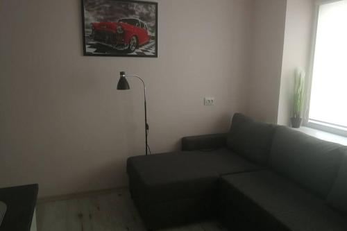 ein Wohnzimmer mit einem Sofa und einem roten Truck an der Wand in der Unterkunft T&J Appartments Ferry Terminal in Klaipėda