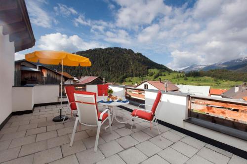 a patio with a table and chairs on a roof at Ferienhaus Luis in Nauders