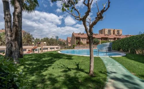 uma piscina num parque com palmeiras em Palau de Vic em Valência