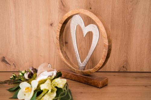a wooden heart mirror and flowers on a table at ROCHUS APPARTEMENTS in Sautens