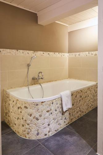 a bathroom with a bath tub with a shower at Mein Nordstern in Humptrup