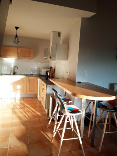 Il comprend une cuisine avec une table et des chaises en bois. dans l'établissement T3 duplex lumineux en centre-ville (plage à 10mn), à Soustons