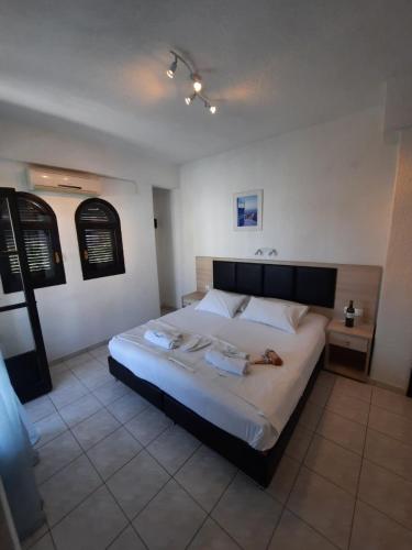 a bedroom with a large bed with two towels on it at Tassos 2 in Pefkohori