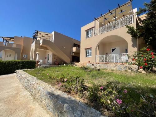 a building with a yard with flowers in front of it at Nostalgia Villas in Tersanas