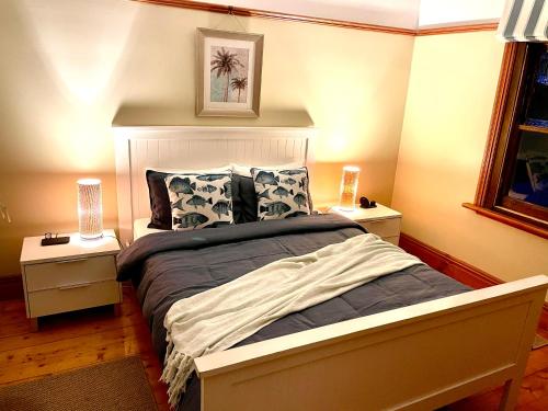 1 dormitorio con 1 cama grande y 2 mesitas de noche en Sinnamon's By The Sea, en Kilcunda