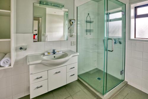 a bathroom with a sink and a glass shower at Ika Nui Taupo in Taupo