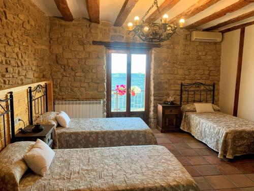 Ujué的住宿－Casa Rural Las Migas，一间卧室设有两张床和窗户。