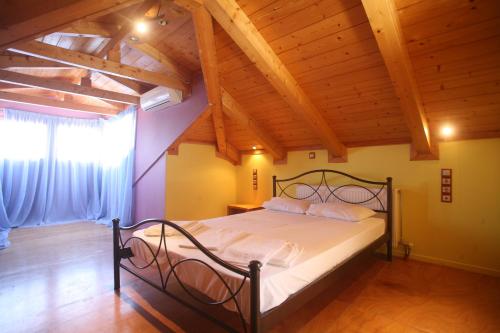 una camera con letto in una stanza con soffitti in legno di Pension Maria a Città di Lefkada